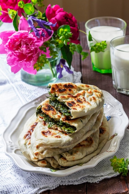 Traditional armenian flatbread with greens zhengyalov hats served with yogurt on the background of a