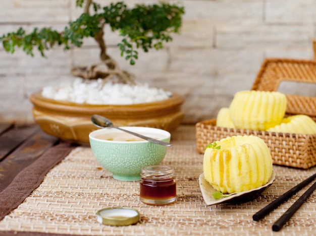 Traditional asian rice cake with honey and green tea on a wooden background