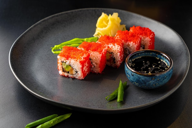 Traditional Asian rolls and sushi with soy sauce and wasabi served on a dark background