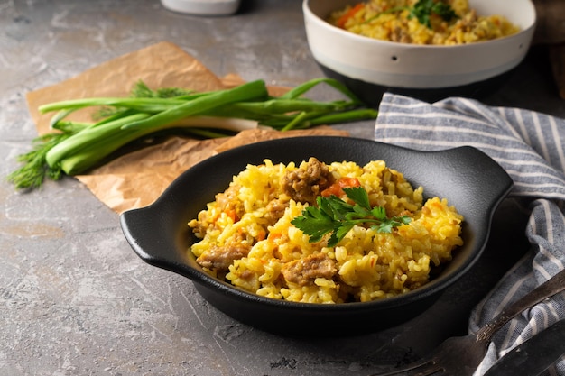 Traditional azian pilaf served in plate on gray background