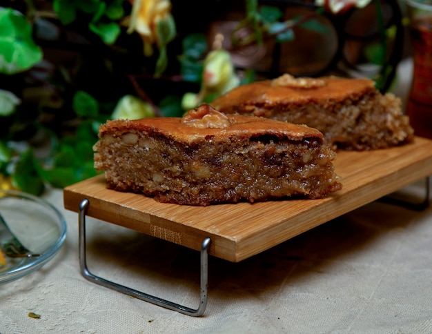 Traditional baklava on small wooden table with greenery