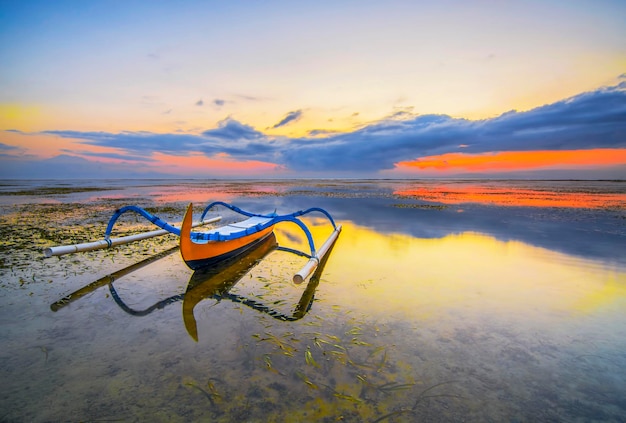 Traditional balinese jukung fishing boats on Sanur beach during beautiful sunrise at Bali Indonesia