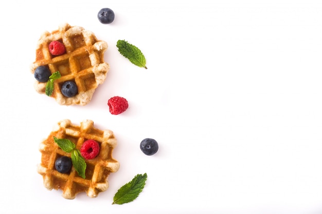 Traditional belgian waffles with blueberries and raspberries, isolated on white background