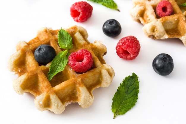 Traditional belgian waffles with blueberries and raspberries, isolated on white