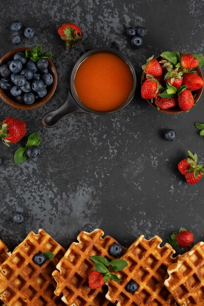 Traditional Belgian waffles with fresh berries and sweet topping and mint