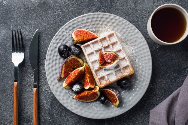 Photo traditional belgian waffles with powdered sugar grapes and figs. 