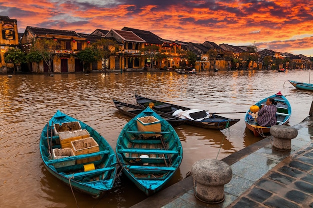 Traditional boats in front of ancient architecture in Hoi An Vietnam