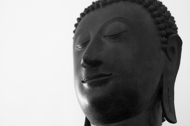 Traditional Buddha head against a white background with copy space