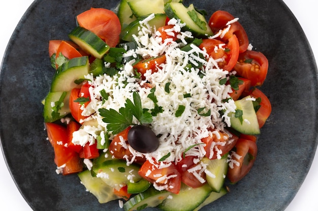 Traditional Bulgarian shopska salad with tomatocucumber and bulgarian sirene cheese isolated on white background