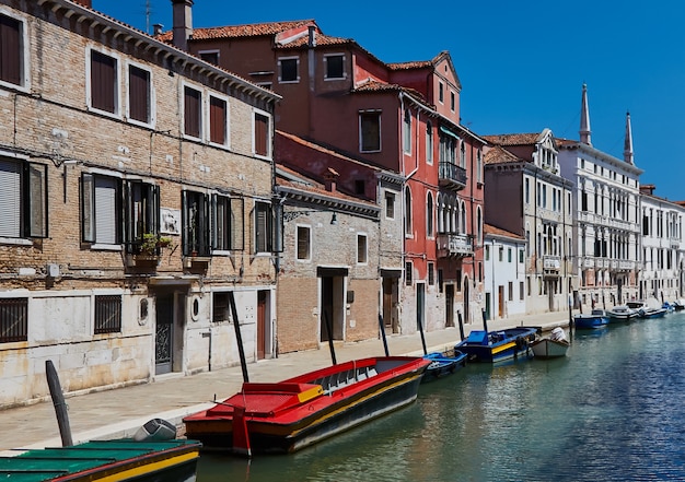 Traditional canal with boats in Venice, Italy. Summer.