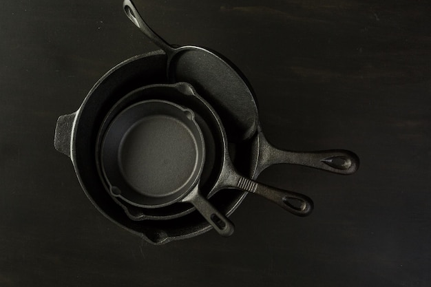 Traditional cast iron skillet on black wood table.