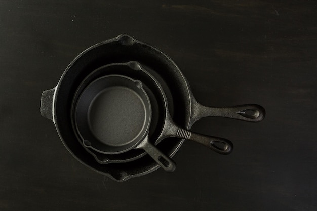 Traditional cast iron skillet on black wood table.