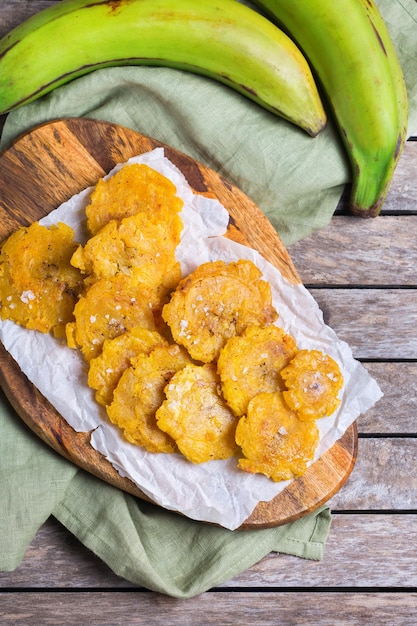 Photo traditional central american caribbean cuban colombian food. fried tostones, green bananas plantains with guacamole sauce. top view, flat lay