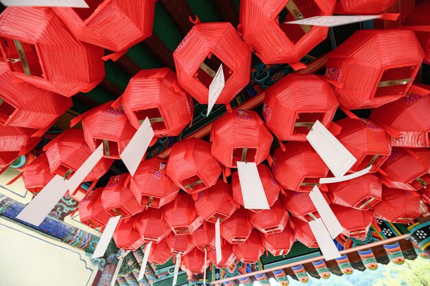 Traditional chinese red lantern with white paper hanging on ceiling of temple