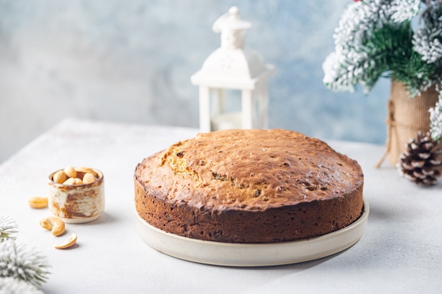 Traditional christmas cake pudding with fruits and nuts with christmas decorations light background