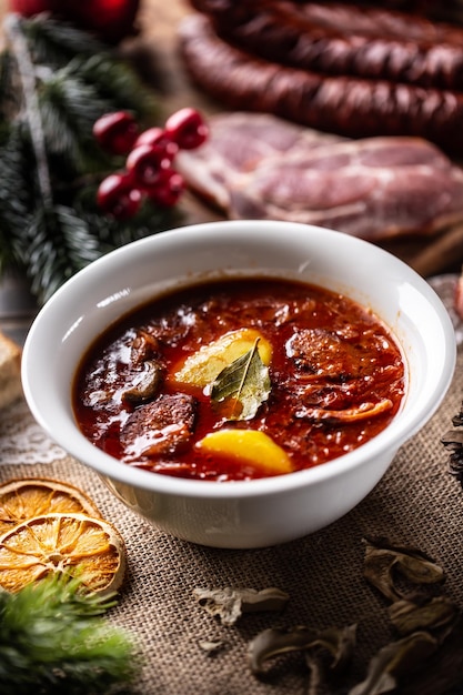 Traditional christmas sour cabbage soup with potatoes sausage smoked pork and mushrooms