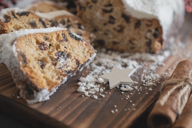 Traditional Christmas stollen made of dried fruits and nuts sprinkled with powdered sugar