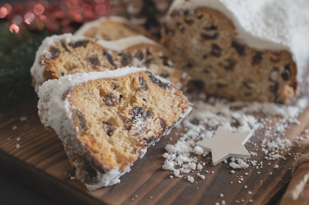 Traditional Christmas stollen made of dried fruits and nuts sprinkled with powdered sugar