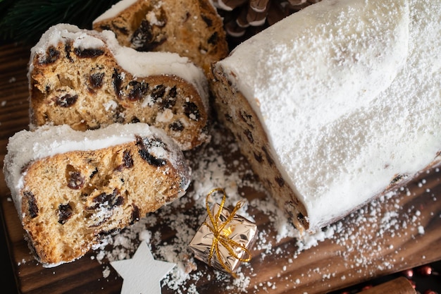 Traditional Christmas stollen made of dried fruits and nuts sprinkled with powdered sugar