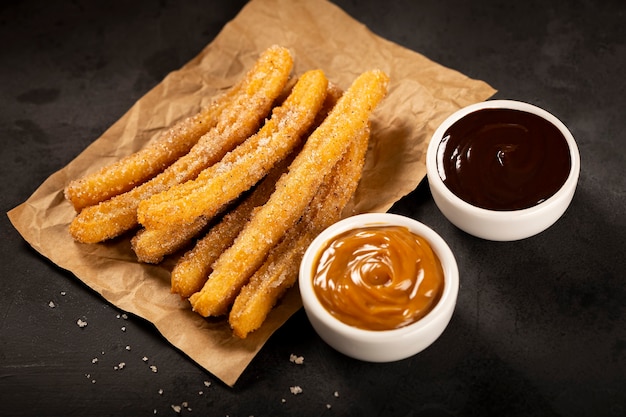 Traditional churros with sugar dulce de leche and chocolate sauce