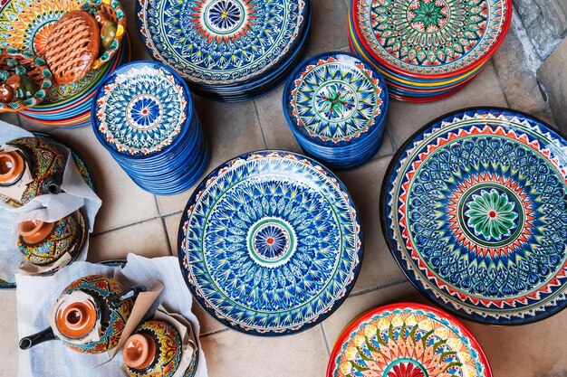 Photo traditional colorful uzbek plates and ceramic dishes handpainted at street oriental bazaar in tashkent in uzbekistan