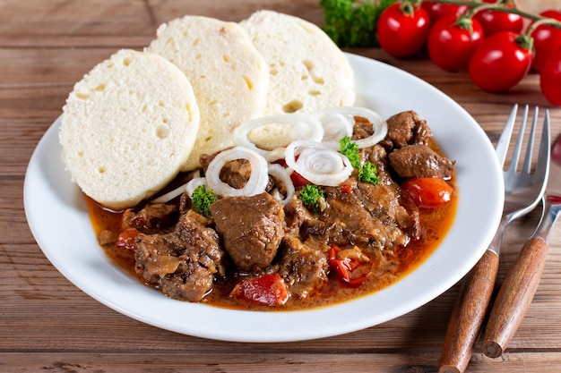 Traditional czech goulash with dumplings on table