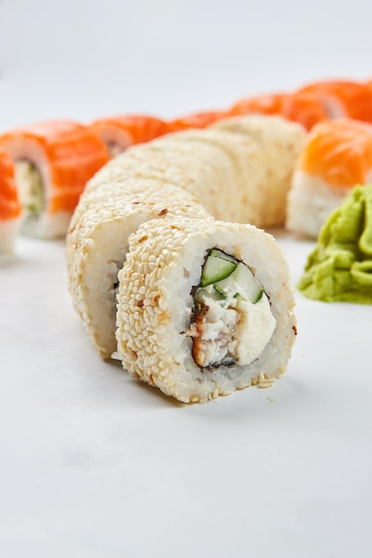 Traditional delicious fresh sushi set Philadelphia roll with salmon smoked eel and cucumber isolated on white background Sushi menu Japanese asian food