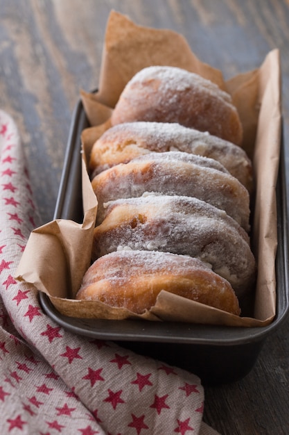 Traditional donuts on wood. Tasty doughnuts with powdered sugar