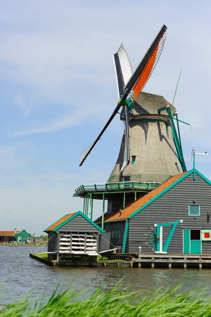 Traditional dutch windmill near the canal in summer day. Netherlands