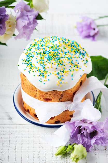 Traditional Easter sweet bread or cakes with white icing and sugar decor and quail eggs over white wooden table Various Spring Easter cakes Happy Easter day Christian traditions Top view