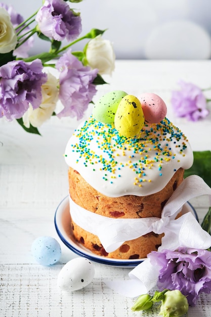 Traditional Easter sweet bread or cakes with white icing and sugar decor and quail eggs over white wooden table Various Spring Easter cakes Happy Easter day Christian traditions Top view