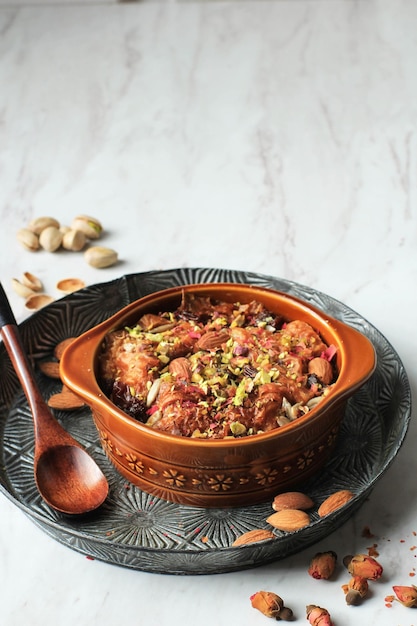 Traditional Egyptian Dessert Bread Pudding "Om Ali" or "Umm Ali" of Soaked Bread, Milk and Load of Roasted Nuts and Raisins.