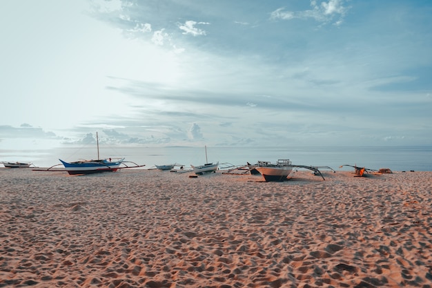 Traditional Filipino boat on a white beach in the sea