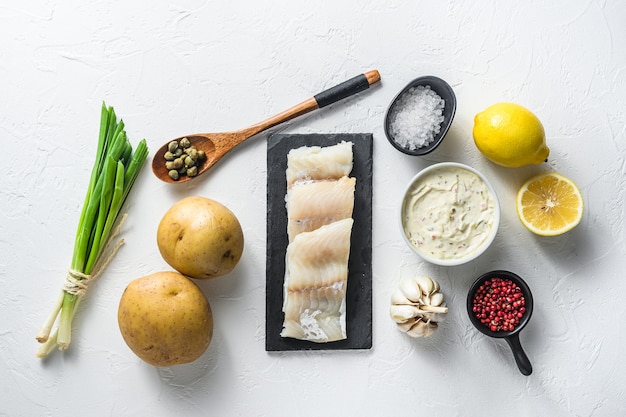 Traditional fish and chips ingredients recipe raw cod fillets on stone slate