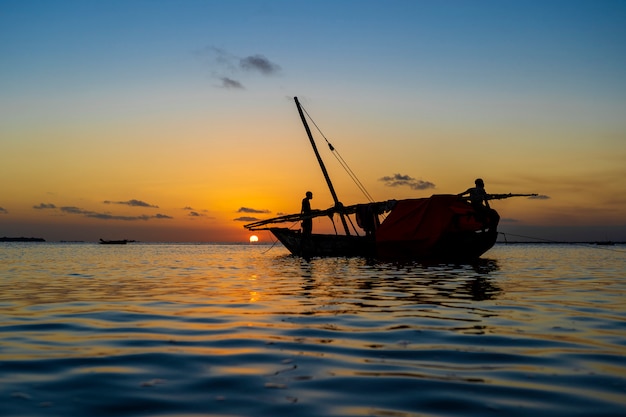 Traditional fisherman dhow boat during sunset on Indian ocean in island Zanzibar, Tanzania, East Africa