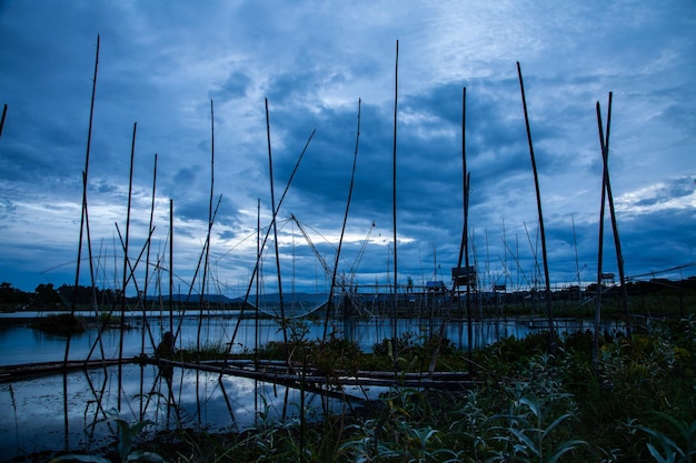 Traditional fishing tool or bamboo fish trap on sunset light landscape silhouette