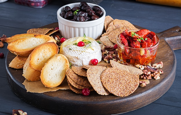 Traditional french baked camembert cheese with thyme and toast, walnuts, olives, sun dried tomatoes, and flax chips.