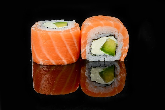 Traditional fresh japanese sushi rolls on a black background