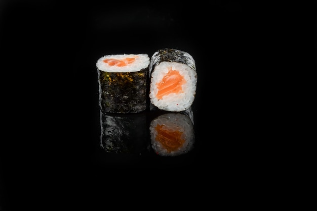 Traditional fresh japanese sushi rolls on a black background