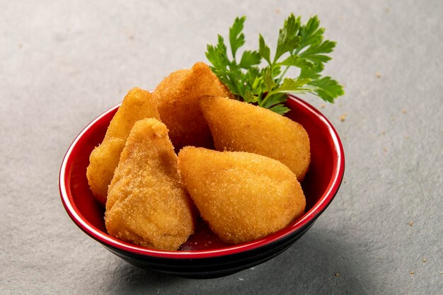 Traditional fried coxinha in plate on slate background popular brazilian snack