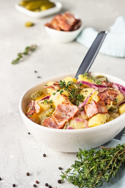 Traditional German potato salad with cucumber, onion and bacon Kartoffelsalat.