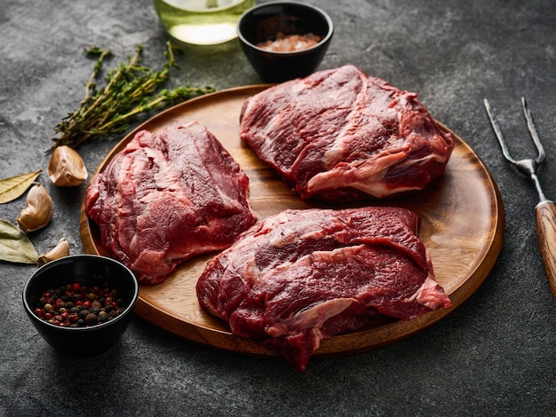 Traditional German raw beef cheeks offered as closeup with herb and spices