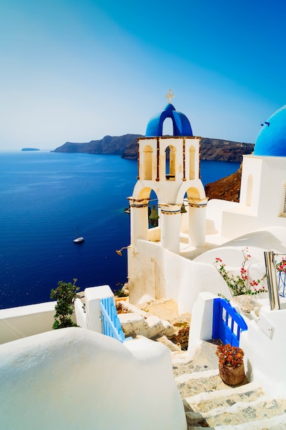 Traditional greek village Oia of Santorini, with stairs and blue dome, Greece, toned