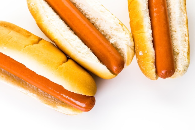 Traditional hot dogs on a white hot dog bun on a white background.