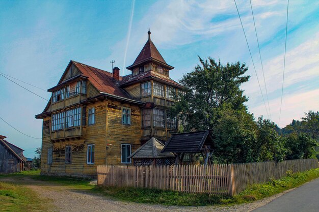 Photo traditional hutsul house in the carpathians in the forest on a sunny summer day village twostorey house in ukraine galicia