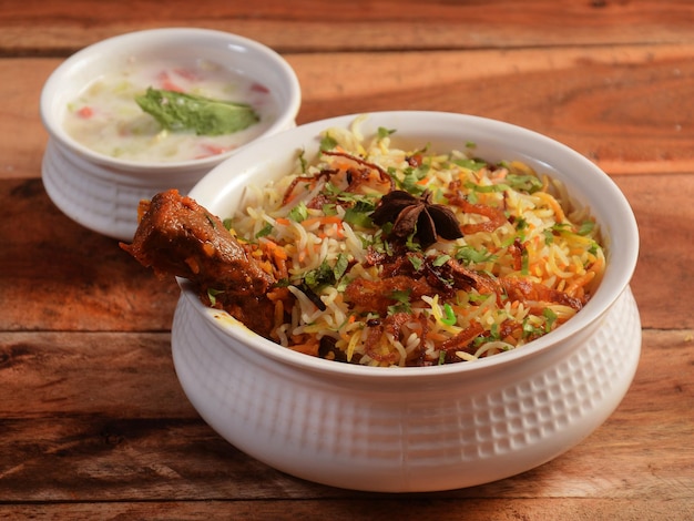 Traditional Hyderabadi Chicken dum Biryani made of Basmati rice cooked with masala spices served with Onion raita selective focus