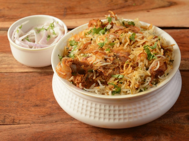 Traditional Hyderabadi Chicken dum Biryani made of Basmati rice cooked with masala spices served with Onion raita selective focus