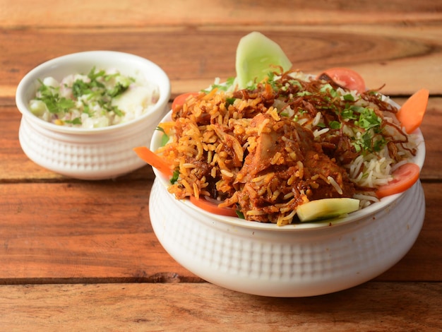 Traditional Hyderabadi Chicken dum Biryani made of Basmati rice cooked with masala spices served with Onion raita selective focus