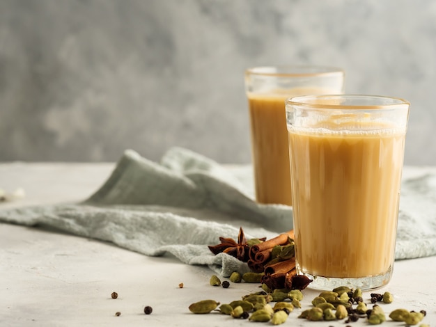 Traditional Indian drink Masala tea on a light background with spices. Copy space.