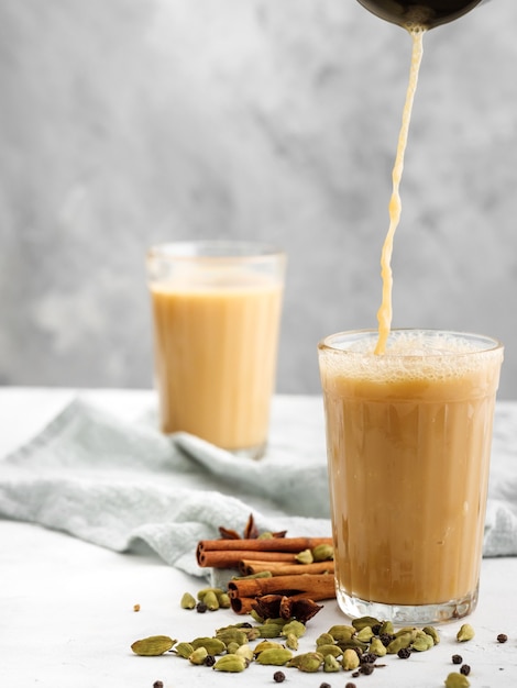 Traditional Indian drink Masala tea on a light background with spices. Copy space.